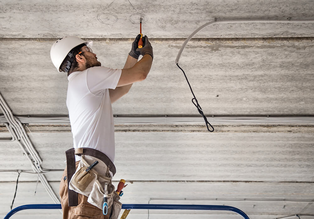 Electrician working on wires in ceiling